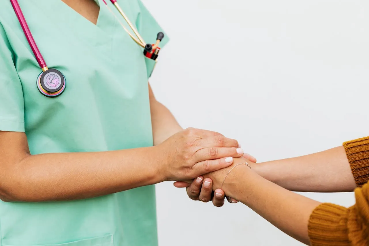 A clinician holding a patient's hand in a supportive gesture