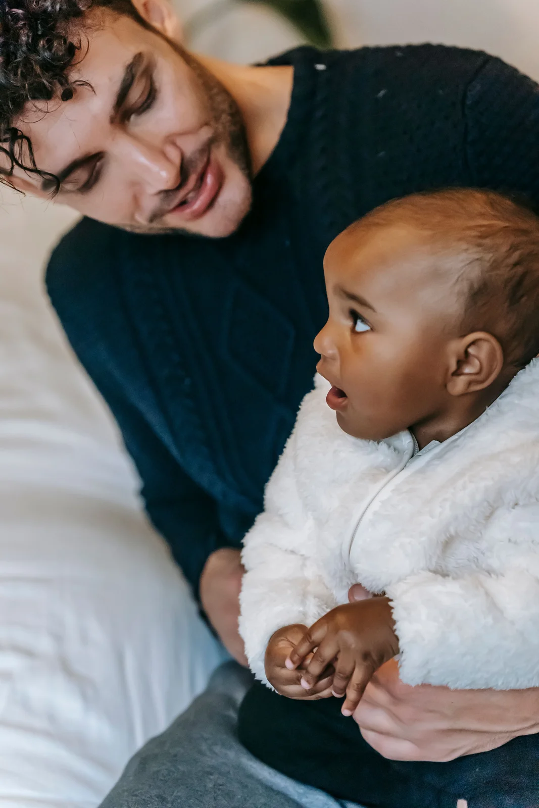 A father smiling down at his infant, representing renewed hope and presence for family after treatment