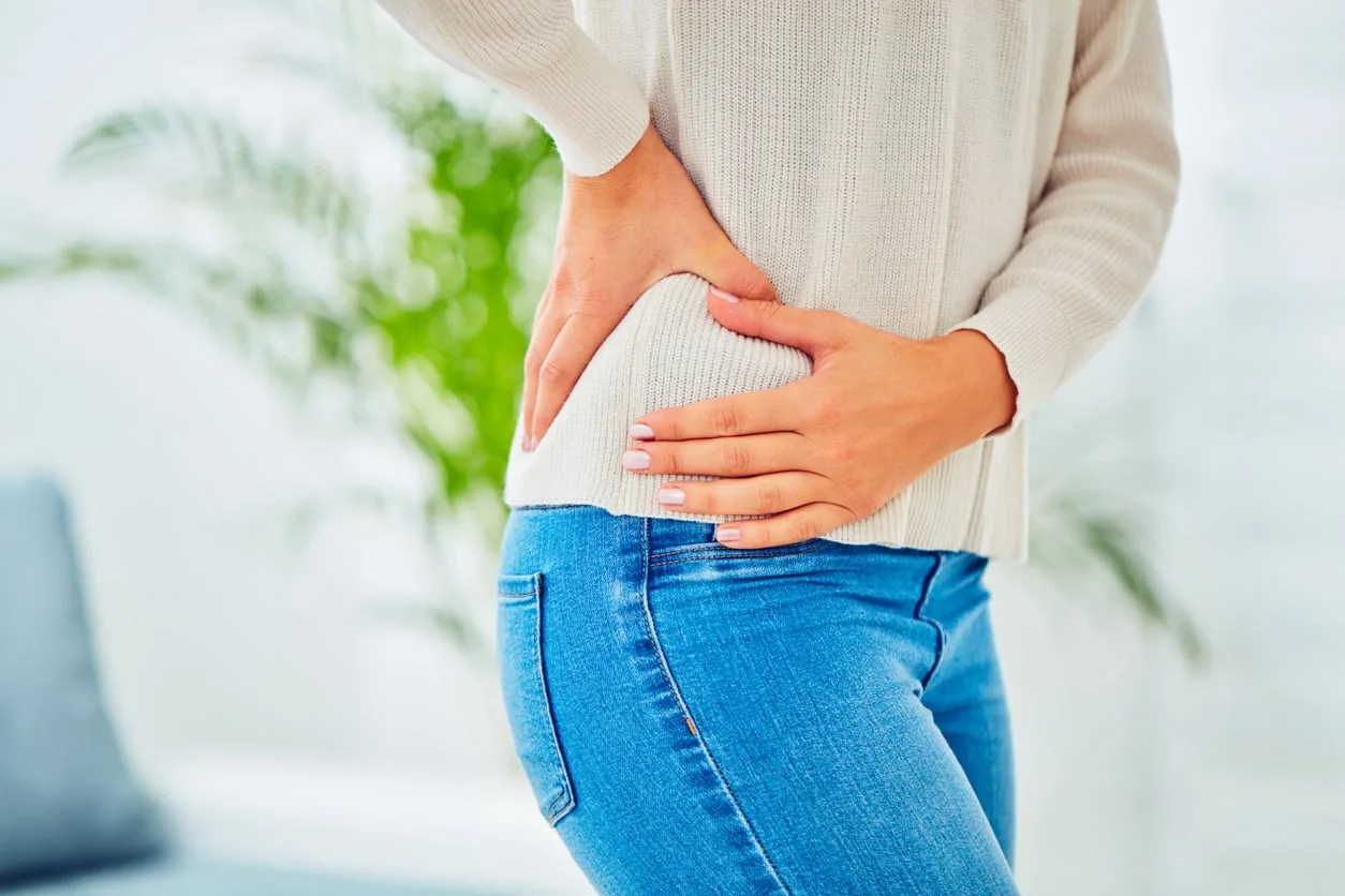 A woman holding her hip, illustrating the joint pain commonly evaluated before an injection