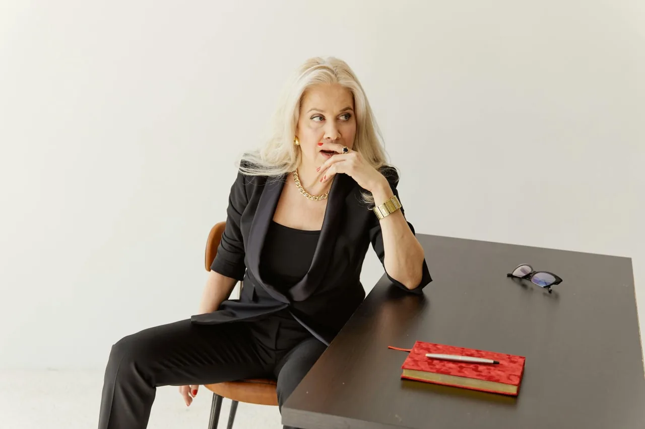 A woman with silver hair sitting at a table, thinking through her options