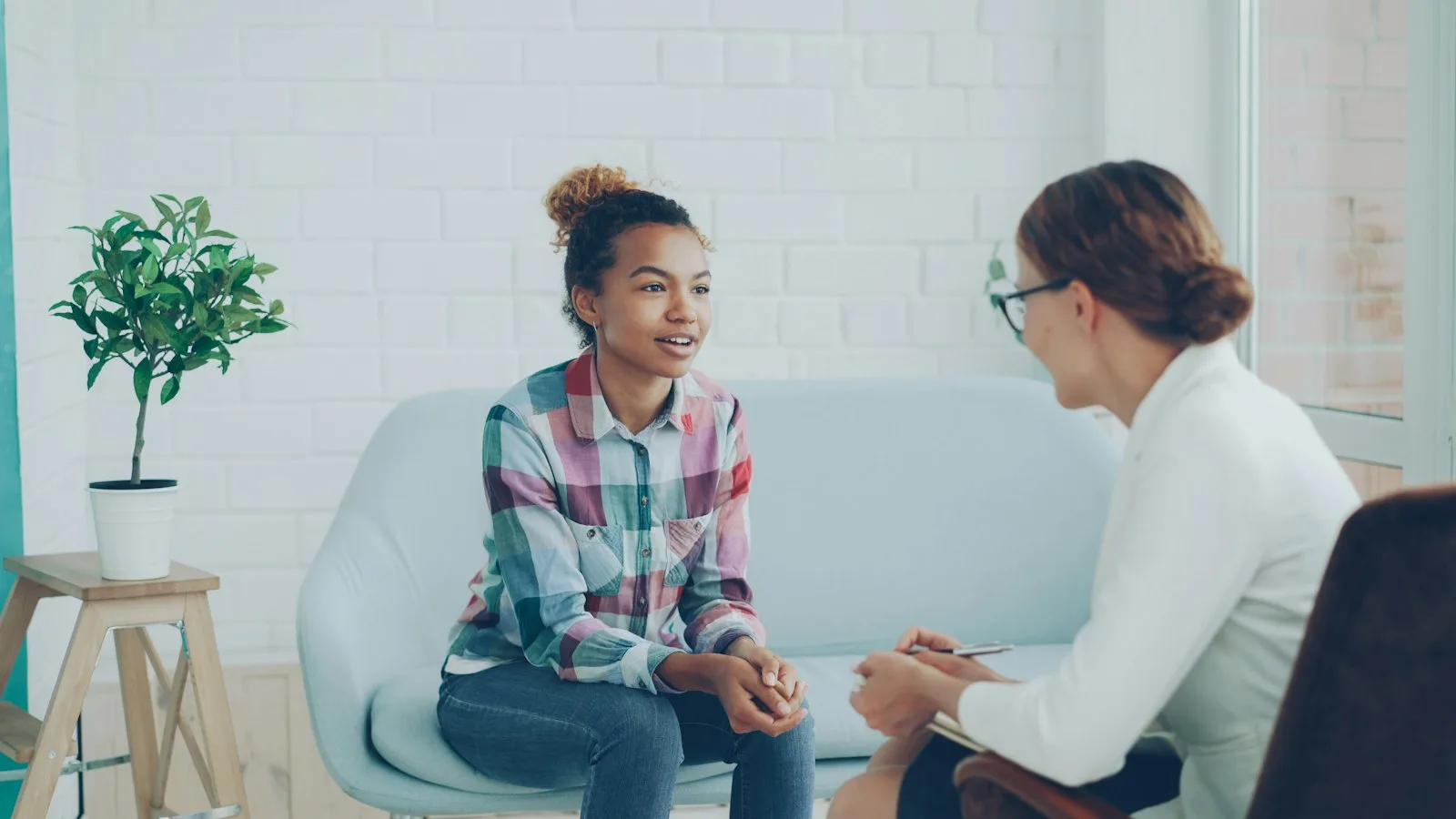 Two women talking in a bright, modern office