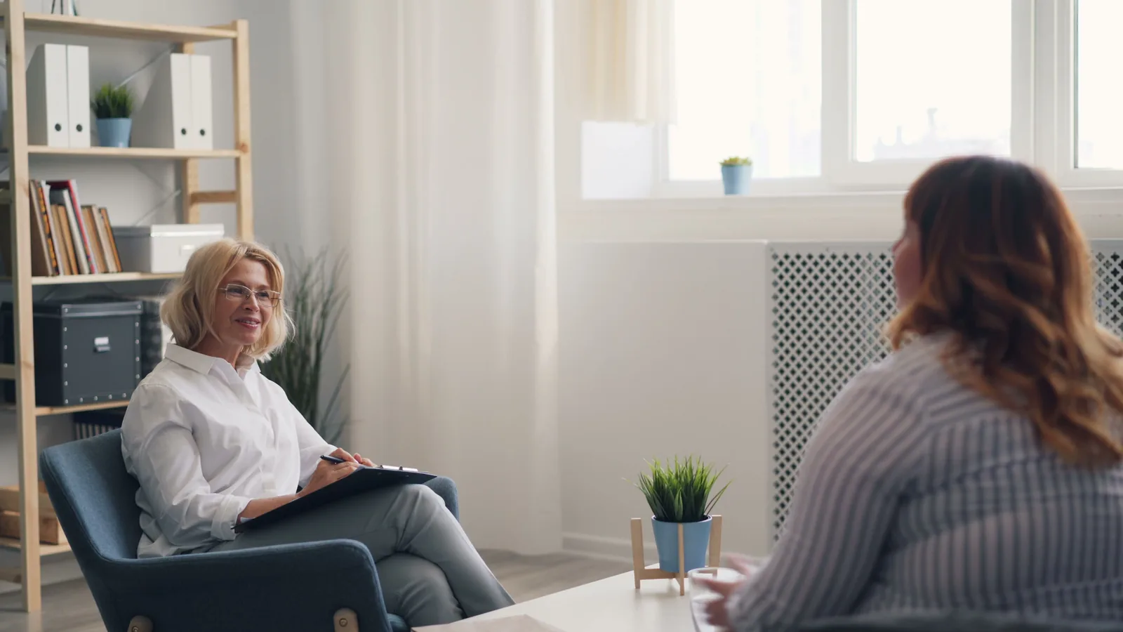 A clinician talking through screening with a patient in a bright, relaxed office