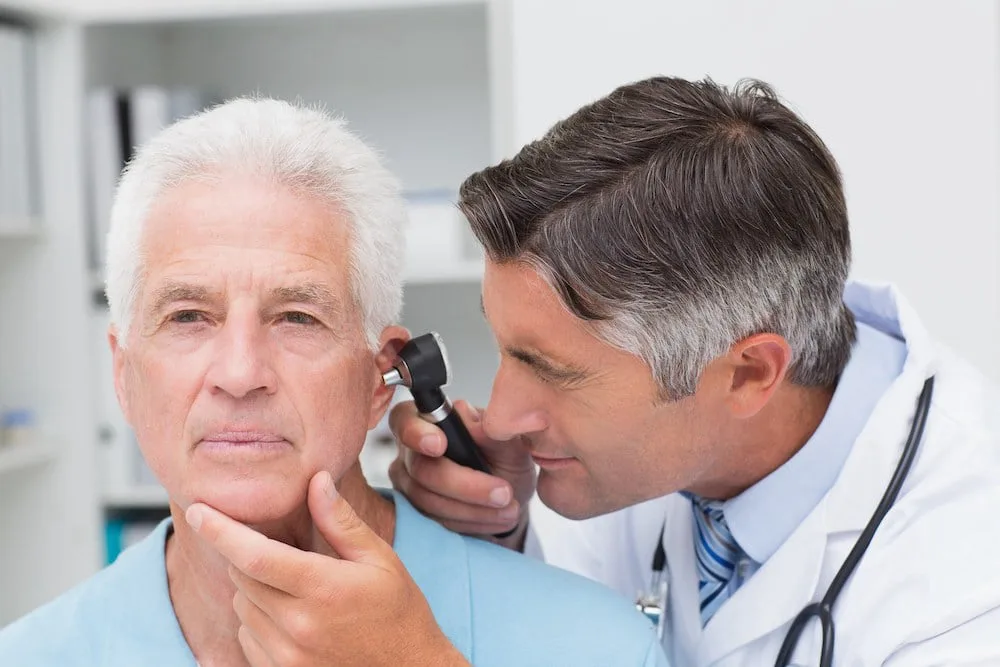 A physician performing a routine ear exam during a preventive checkup