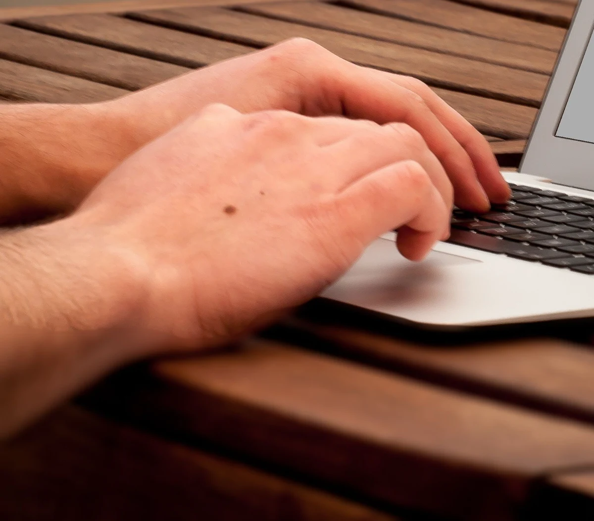 Hands typing on a laptop, accessing the patient portal securely