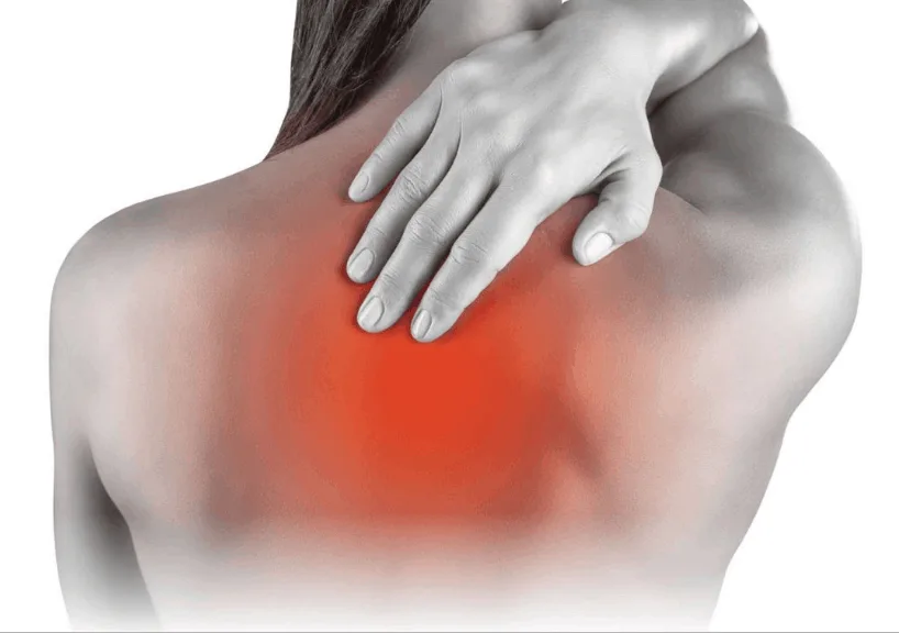 A person holding their upper back and shoulder in pain