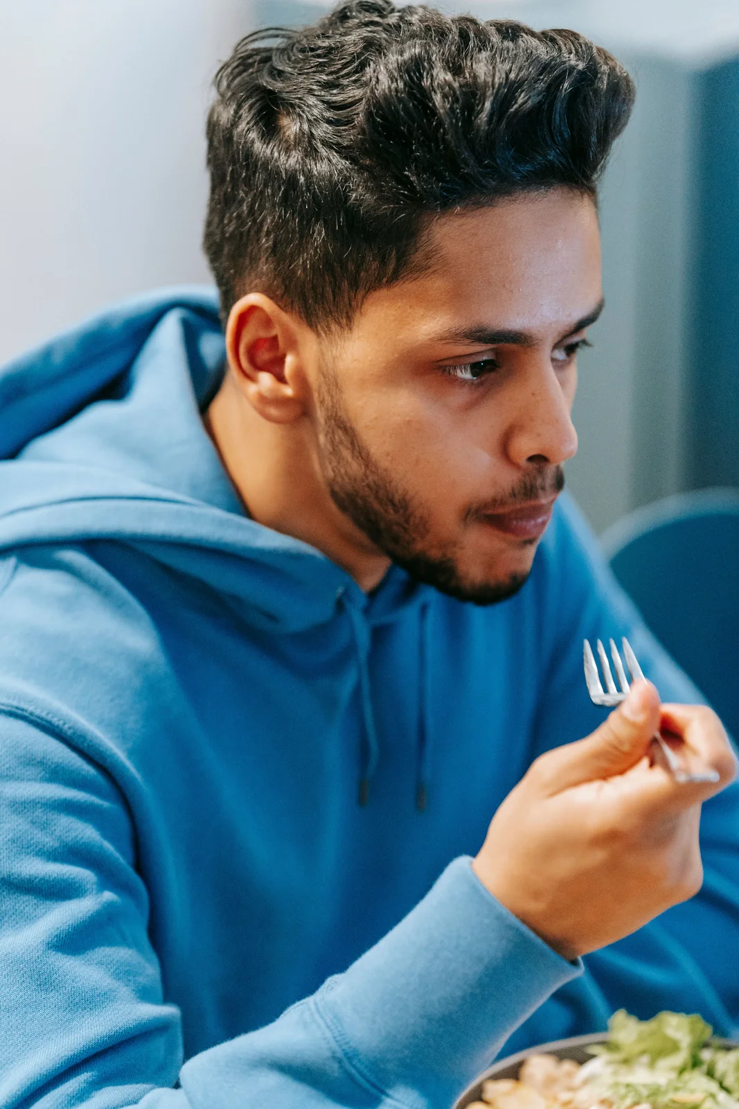 A man looking thoughtfully at a bowl of healthy food, representative of the mindful food choices a prediabetes diet is built around